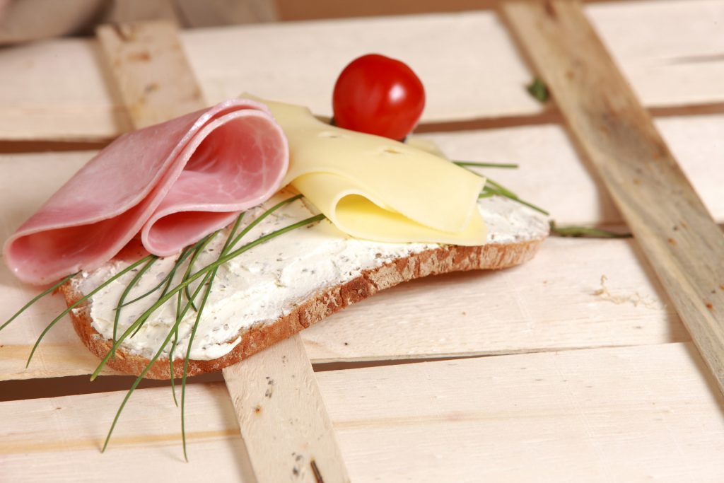 Torrada com presunto, queijos e vegetais representando alimentos variados